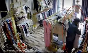 Tên cướp manh động dùng dao khống chế người phụ nữ ở tiệm quần áo