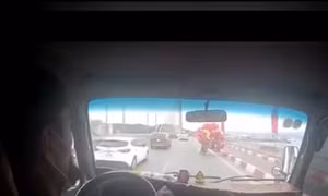 Ấm lòng xe tải che chắn gió cho người bán bóng bay đi qua cầu