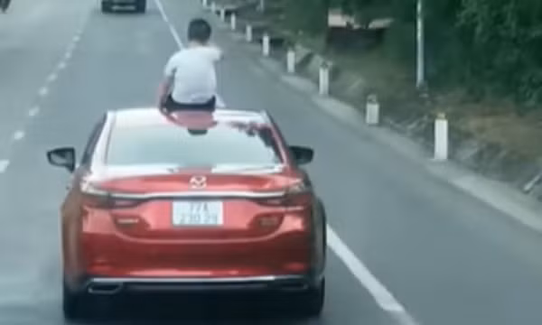 Bị tước GPLX 2 tháng vì để con ngồi trên nóc xe khi đang lưu thông