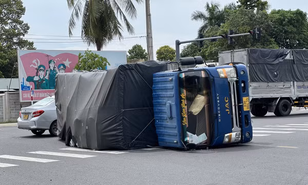 Xe tải chở tôn ôm cua lật nhào, người đi đường suýt chết