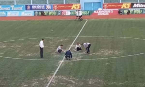 Xịt sơn lên mặt sân vận động để tạo màu xanh
