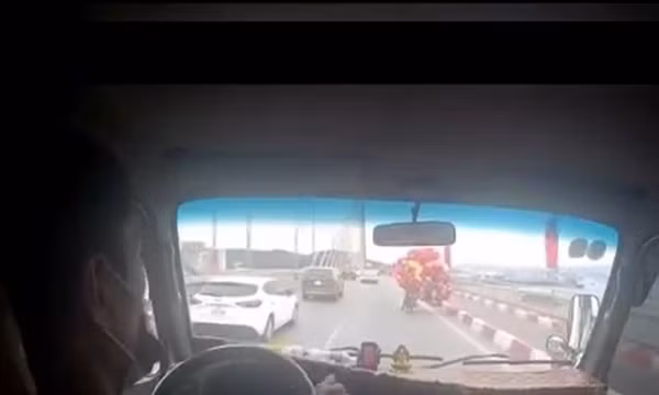 Ấm lòng xe tải che chắn gió cho người bán bóng bay đi qua cầu