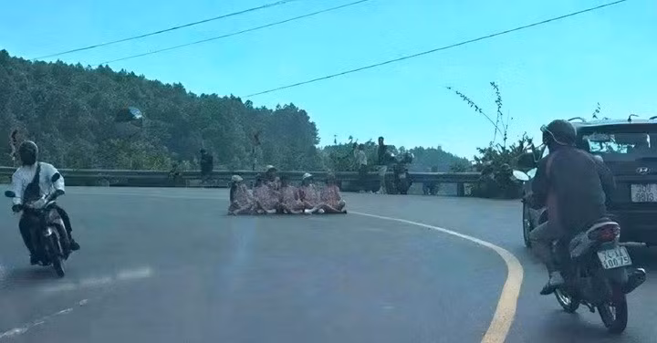 Nhóm phụ nữ ngồi tạo dáng chụp ảnh ngay giữa lòng đường tại khúc cua trên đèo Hải Vân. (Ảnh: MXH)
