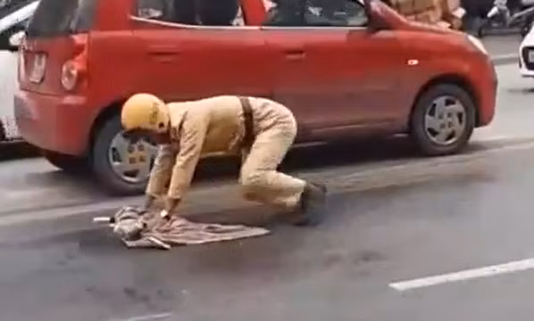 Cảnh sát giao thông lau dầu loang để người đi đường không bị trượt