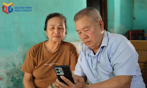 Ông Hải và vợ cùng nhau sử dụng điện thoại thông minh để đăng ký giải quyết các thủ tục hành chính ngay tại nhà.