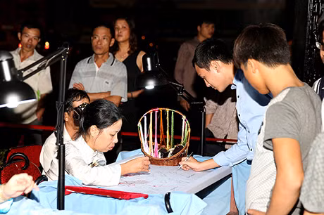 Đại biểu tham quan triển lãm ký tên để được thêu.