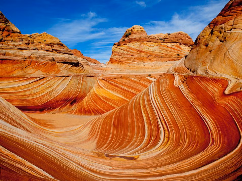 The Wave, Arizona, Mỹ: The Wave là tên các cấu trúc đá sa thạch khổng lồ và tuyệt đẹp ở Arizona. Nằm phía bắc Coyote Buttes ở Arizona, giữa Paria Canyon và khu di tích quốc gia Vermillion Cliffs, những cấu trúc đá này tạo nên các mô hình đầy mê hoặc lượn sóng với màu sắc rực rỡ, thu hút du khách, đặc biệt là các nhiếp ảnh gia trên khắp thế giới. Ảnh: Tu Le/Shutterstock.