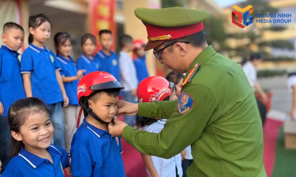 Cán bộ Công an xã Quảng Đức phát tài liệu cho người dân trong buổi tuyên truyền.