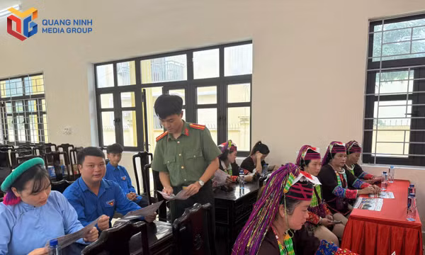 Cán bộ Công an xã Quảng Đức phát tài liệu cho người dân trong buổi tuyên truyền.