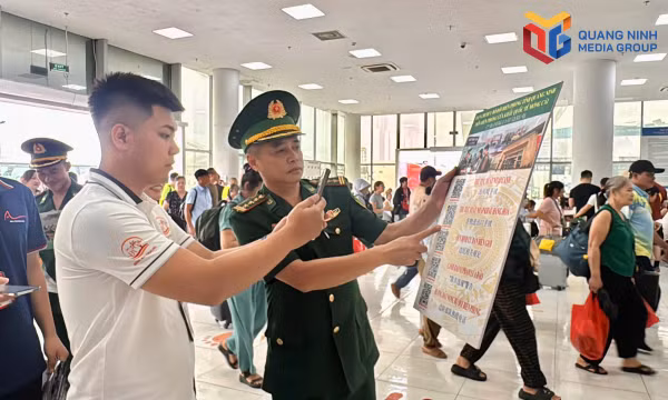 Cán bộ Đồn BPCK quốc tế Móng Cái hướng dẫn người dân, du khách cách quét mã QR tra cứu thủ tục xuất nhập cảnh.