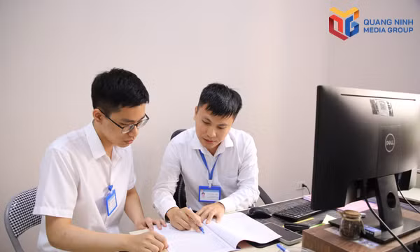 Anh Bùi Công Linh, chuyên viên Phòng Văn hóa - Xã hội, phường Cẩm Phả (bên phải) trao đổi công việc với đồng nghiệp.